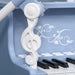 Close-up of blue kids piano with white treble clef detail and black keys
