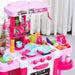 Pink kids kitchen playset with toy stove, oven, sink, utensils, pots, and plastic food