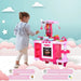 Girl playing with pink kids kitchen playset featuring oven, sink, and toy food accessories