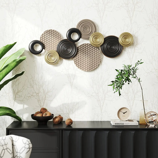 Decorative wall art with circular patterns on a white wall above a black console table.
