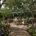 3x3m steel pergola with retractable anthracite canopy, patio furniture, and garden flowers