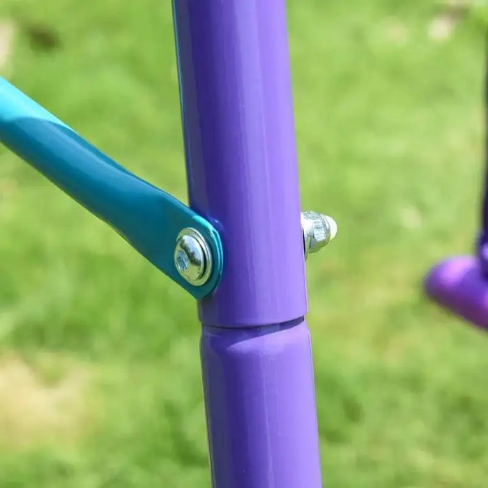 Close-up of purple and blue metal frame on children's garden swing set outdoors
