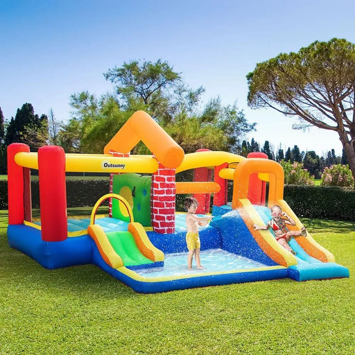 Kids playing on Outsunny inflatable bouncy house with twin slides, pool, and climbing wall outdoors