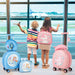 Two children with colorful suitcases at an airport.