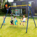 Kids play on yellow and blue 4-in-1 swing set with basketball hoop in a backyard