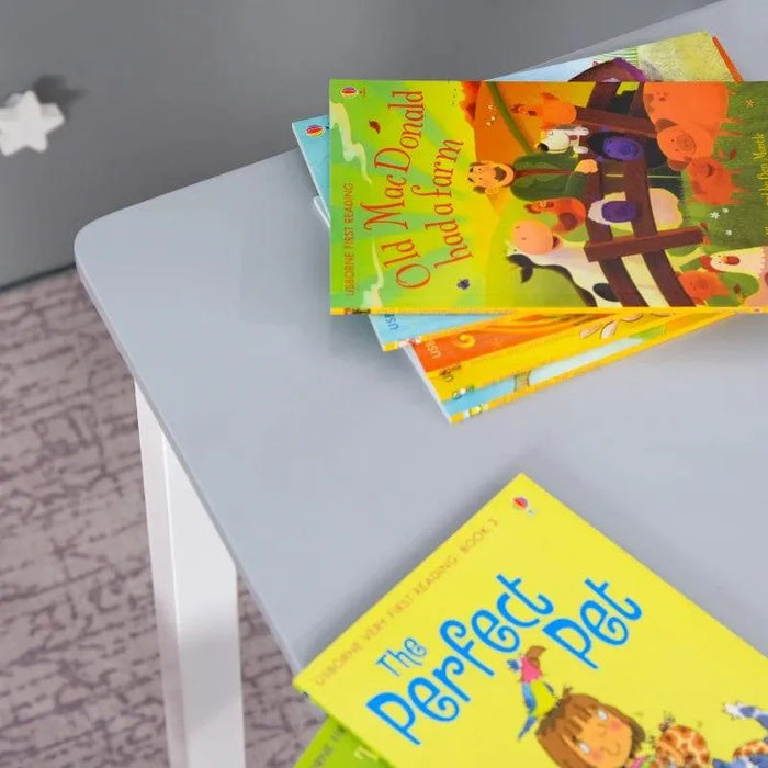 Grey kids table with white legs and colorful children's books on top