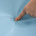 Finger pressing into soft blue foam play mat close-up