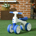 White and blue 4-wheel kids balance bike on artificial grass with brick wall background