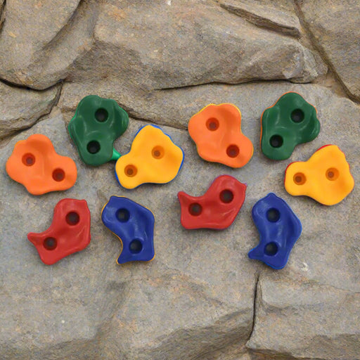 Colorful kids climbing wall rock holds set on a textured stone background