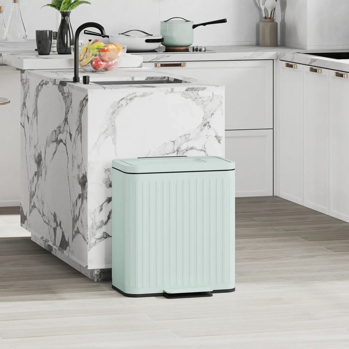Mint green trash can in a kitchen setting with marble island and white cabinets.