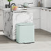 Mint green trash can in a kitchen setting with marble island and white cabinets.