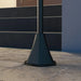 Black metal street lamp base on stone tile pavement near dark stairway with handrail