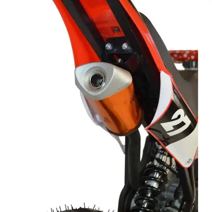 Close-up of red kids mini dirt bike exhaust, rear shock absorber, and number 21 plate