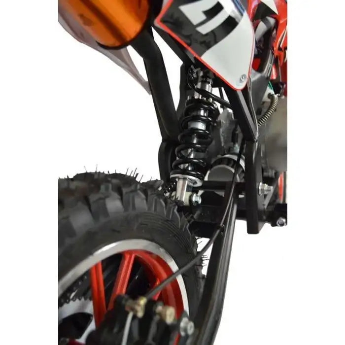 Close-up of rear suspension and tire on red kids mini dirt bike for off-road riding