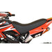 Red kids mini dirt bike with black seat and bold graphics, side view close-up.