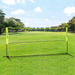 Portable badminton net with adjustable height set up on green grass field outdoors