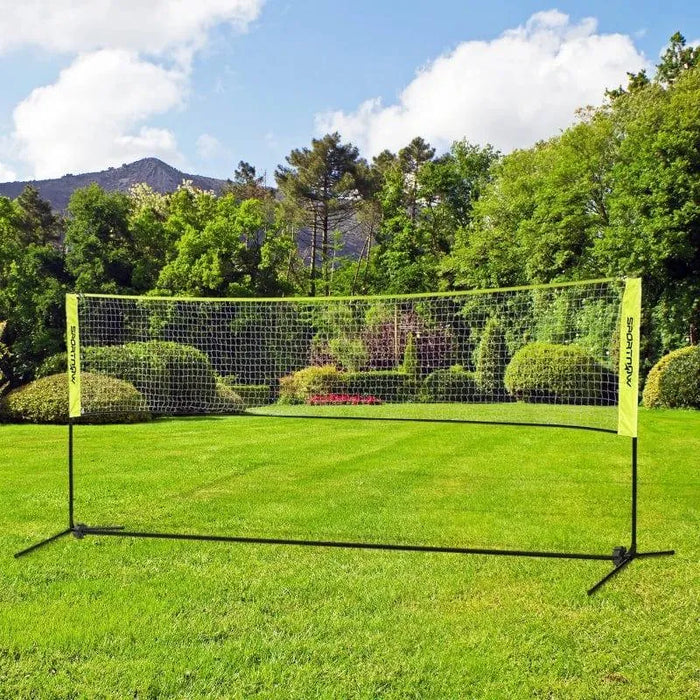 Portable badminton net with adjustable height set up outdoors on green grass lawn