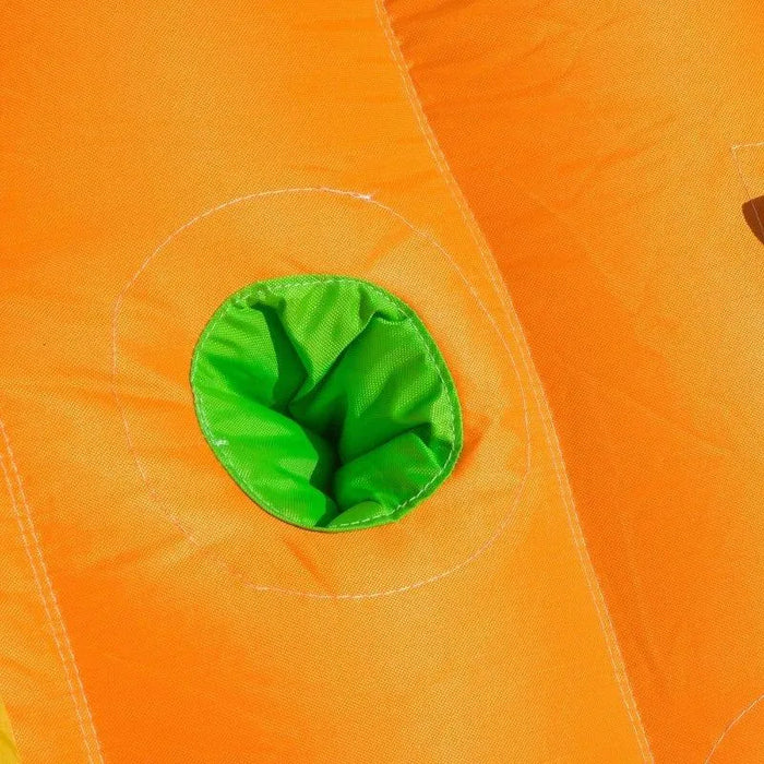 Close-up of orange inflatable bounce house fabric with a green tunnel opening