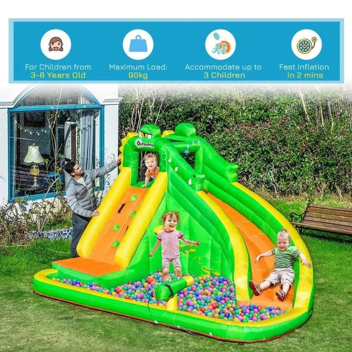 Kids playing on green and yellow inflatable garden water slide with ball pit and climbing wall