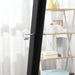 Close-up of a black umbrella with a white handle against a blurred indoor background