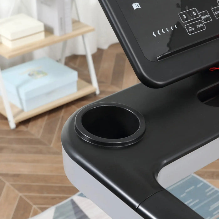 Close-up of a treadmill with a cup holder and control panel in a home setting.