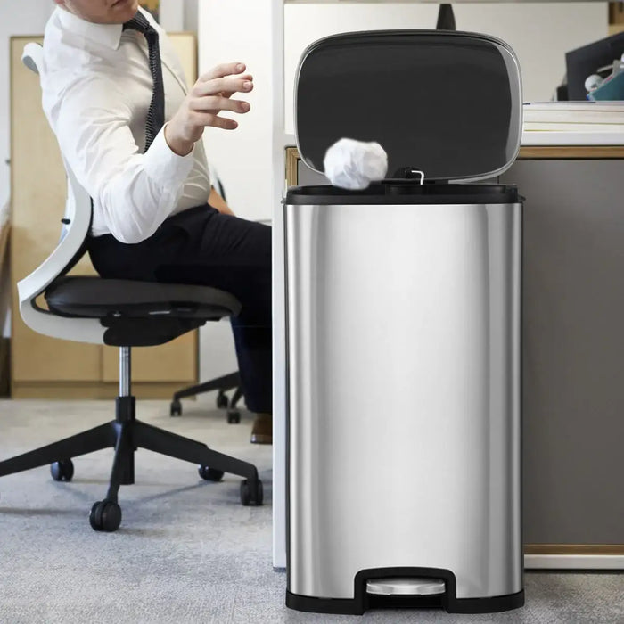 Stainless steel trash can with a foot pedal in an office setting