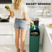 Woman disposing food waste in a green touchless sensor rubbish bin in a modern kitchen
