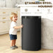 Black trash can with child touching it in a kitchen setting, featuring 'Stainless Steel Housing' text.