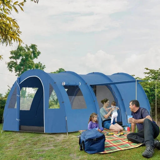 Large blue two-room tent with family camping outdoors on grass, picnic setup in front.