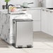 Stainless steel trash can in a modern kitchen with marble island