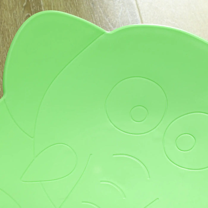 Green foam mat with circular patterns on a wooden floor