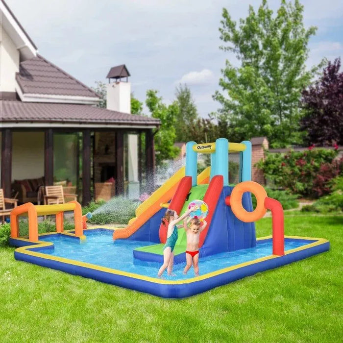 Kids playing on a 6-in-1 inflatable water park with slide, pool, and sports features in backyard