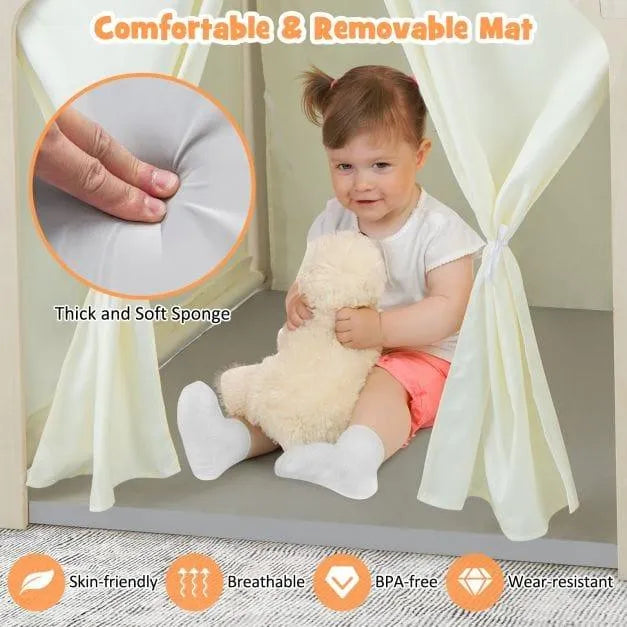 Toddler in indoor playhouse with soft, removable mat, holding teddy bear, Montessori activity center