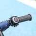 Close-up of a motorcycle handlebar with throttle grip and blue sleeve against a light blue background