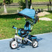Children's tricycle with blue canopy on a paved path in a park.