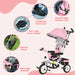 Pink and gray baby tricycle with features highlighted on a pink background