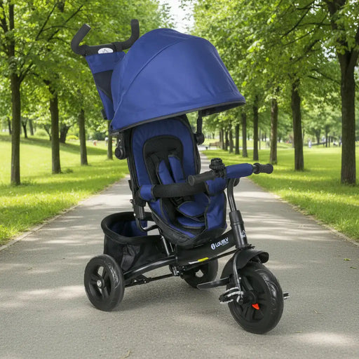 Blue and black stroller on a paved path in a park with green trees.