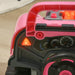Close-up of pink kids toy car dashboard with speedometer and light-up warning symbol