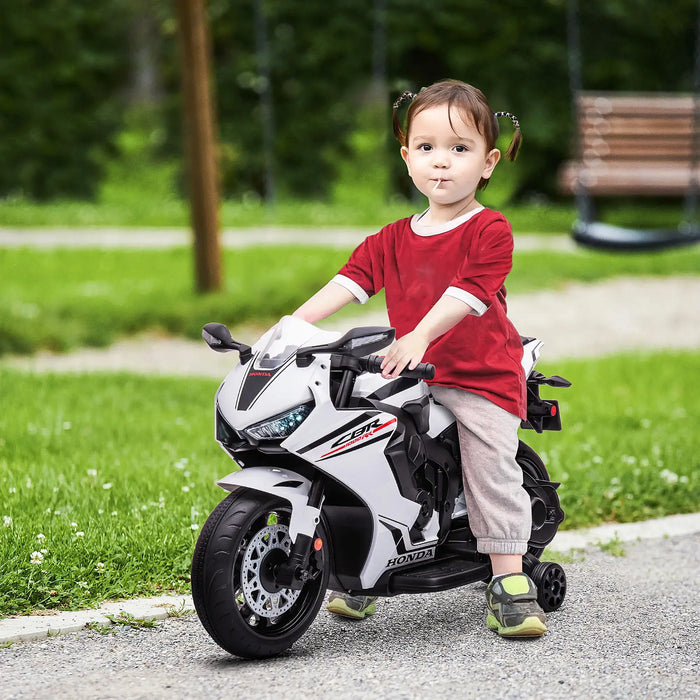 Child sitting on a toy motorcycle in a park