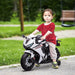 Child sitting on a toy motorcycle in a park