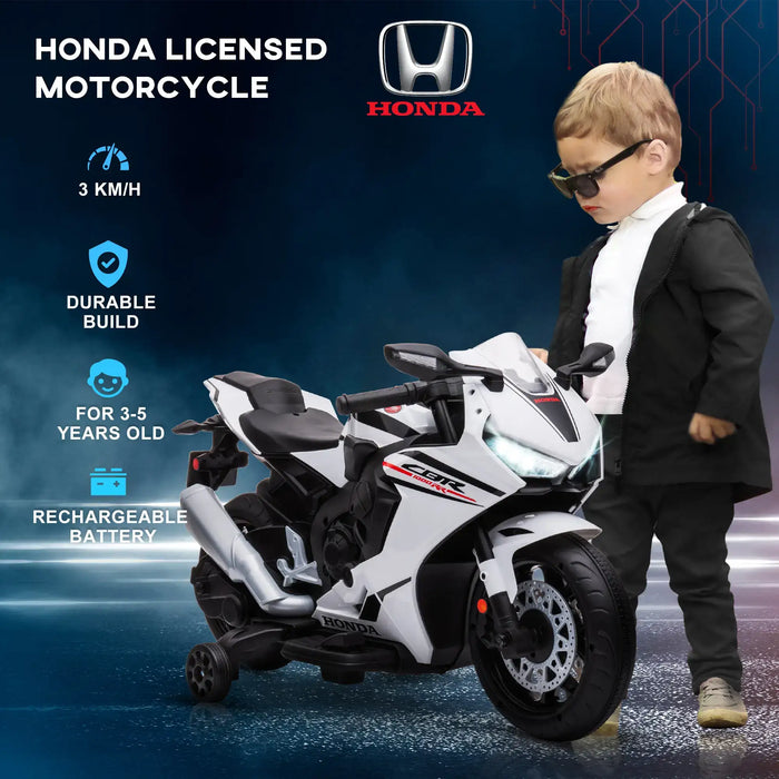 Child with a Honda licensed toy motorcycle on a dark background