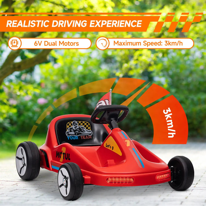 Red toy go-kart with orange accents on a paved surface with greenery in the background