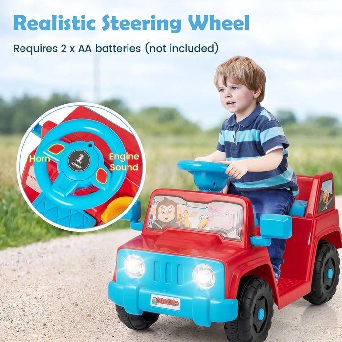 Young boy riding red and blue battery-powered toy jeep with realistic steering wheel outdoors