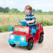 Toddler boy riding red and blue toy car on outdoor path with cartoon animal decals