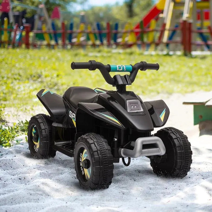 Black 6V kids electric quad bike on sand outdoors near playground equipment