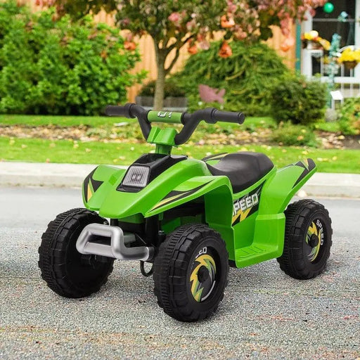 Green kids electric quad bike with black wheels parked outdoors on pavement