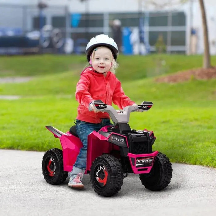Child in helmet riding pink kids electric quad bike outdoors on grass