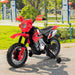 Red and black children's electric dirt bike with training wheels parked on pavement in a sunny park