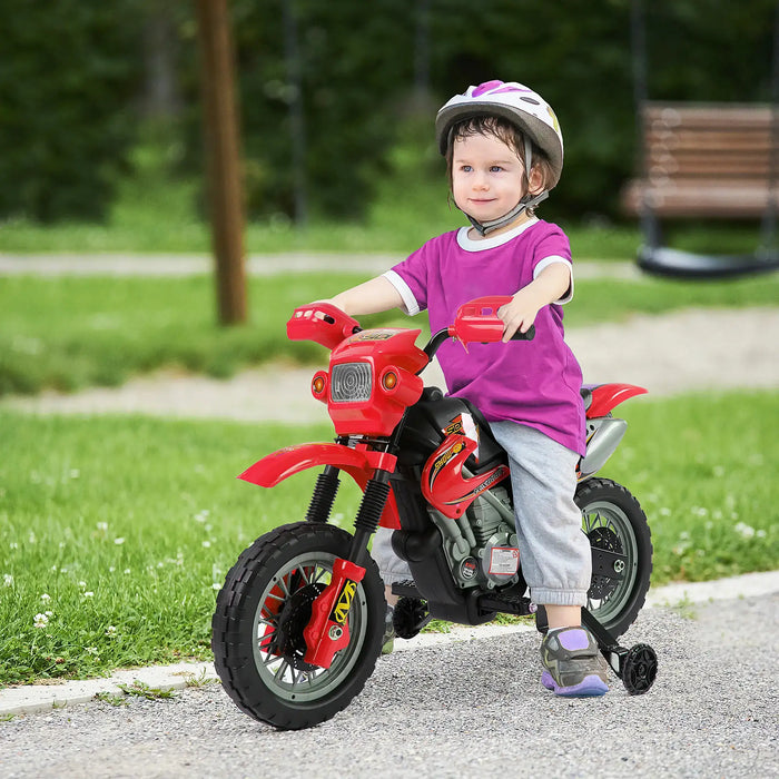 Toddler wearing helmet riding red toy motorcycle with training wheels in park