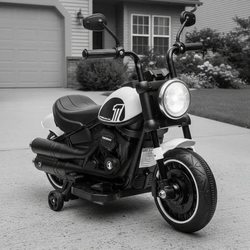 Black and white kids electric motorcycle with training wheels parked on driveway in front of house